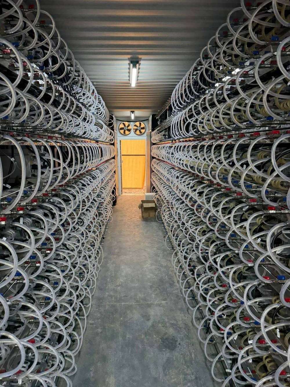 Salle d'hébergement hydro-cooling — allée de machines ASIC